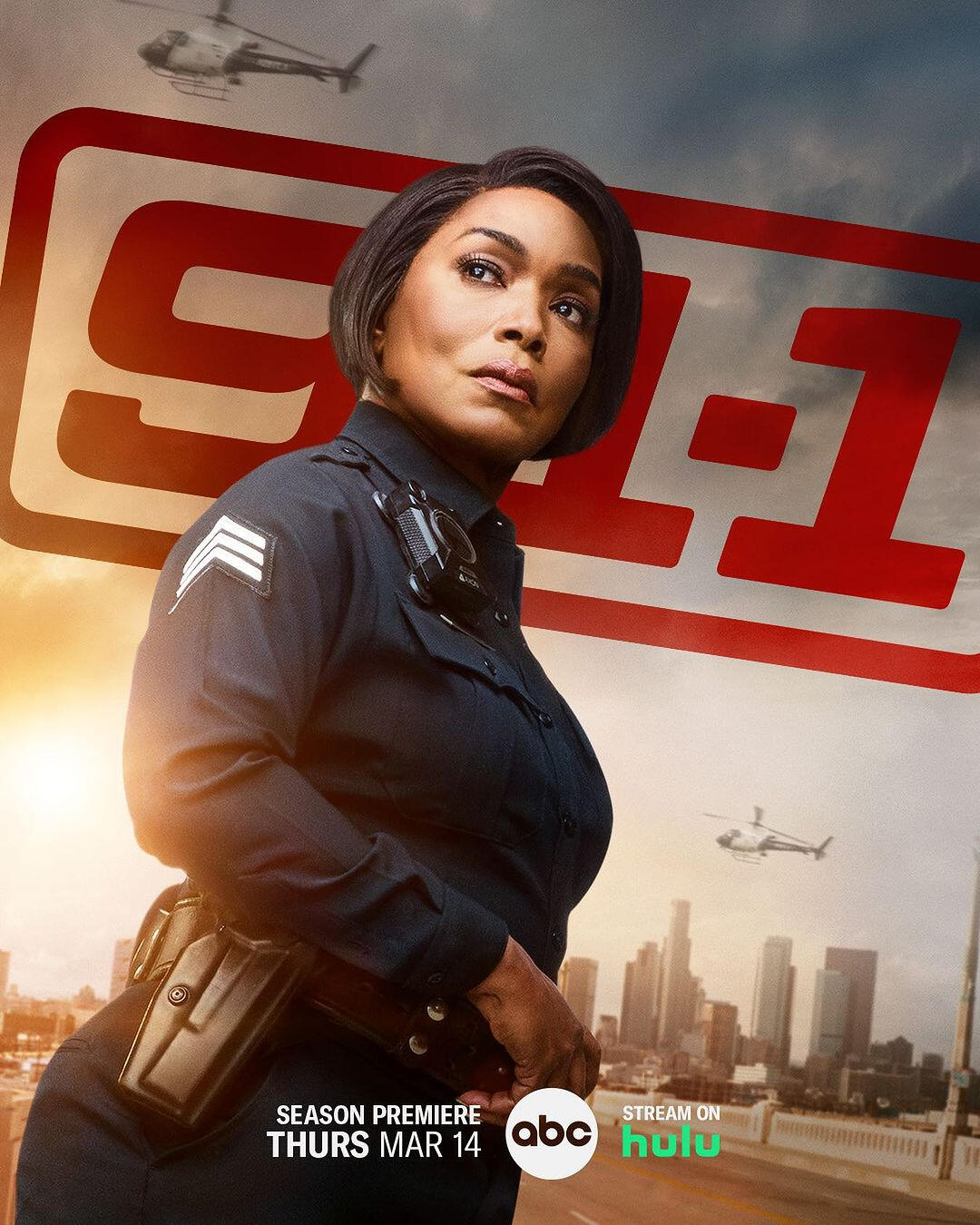 Angela Bassett as Athena on the Season 8 Poster for 9-1-1. She is wearing a straight bob and wearing her black police uniform with the red 9-1-1 logo, the Los Angeles skyline and helicopters in the background.